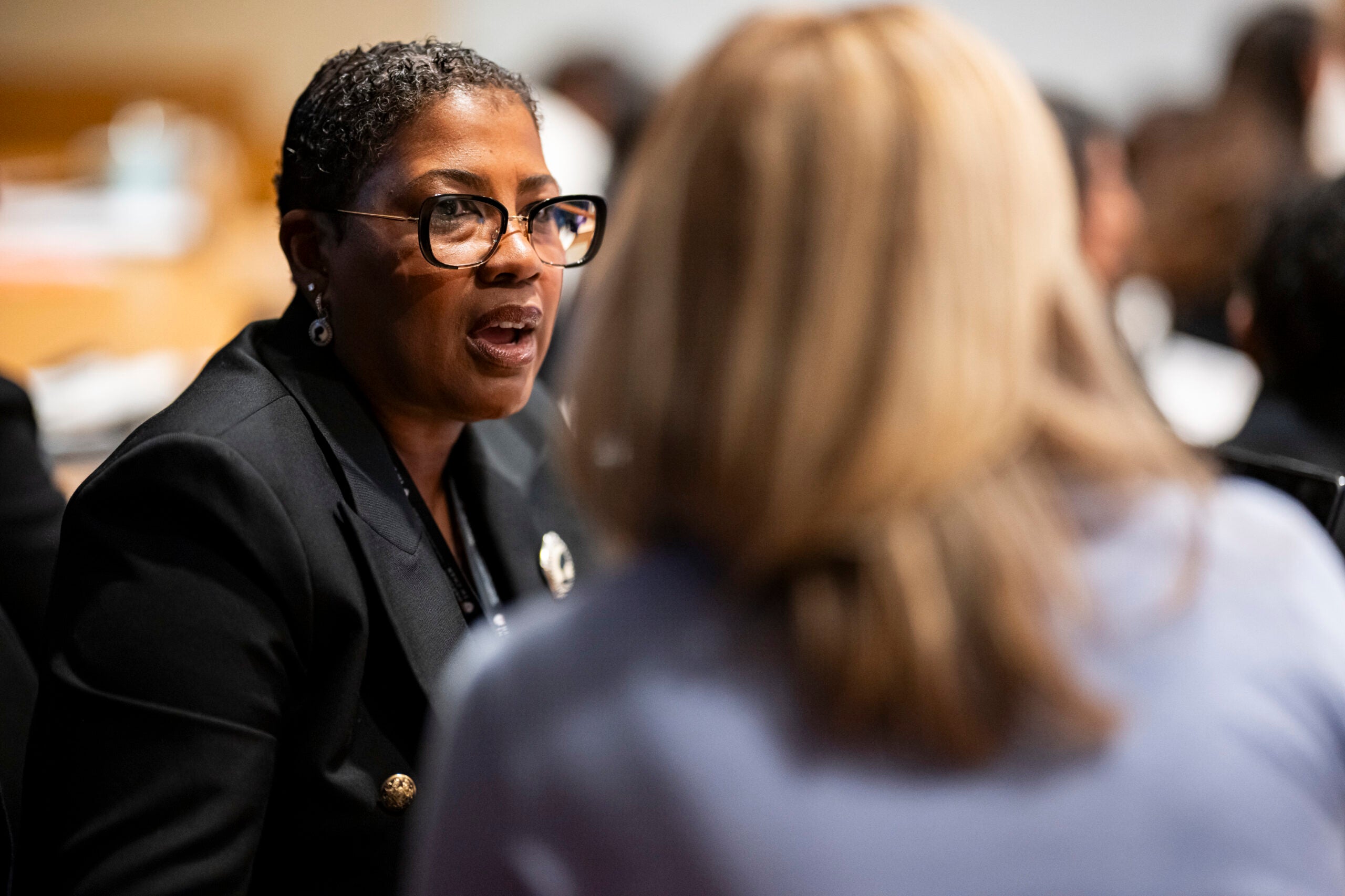 Close-up image of a participant in a Harvard Chan School classroom speaking with another participant.