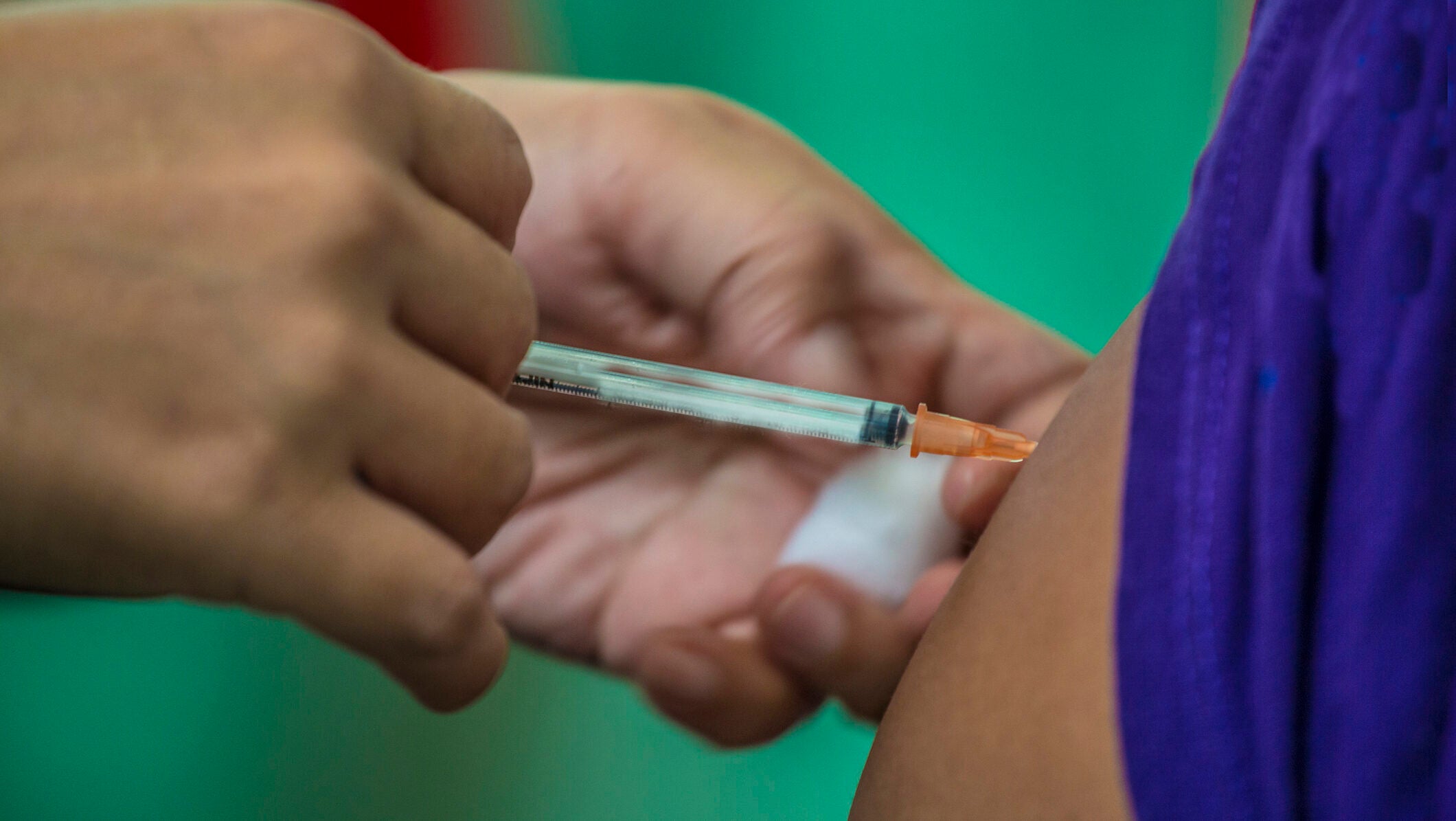 A person receives a vaccine shot in the arm.